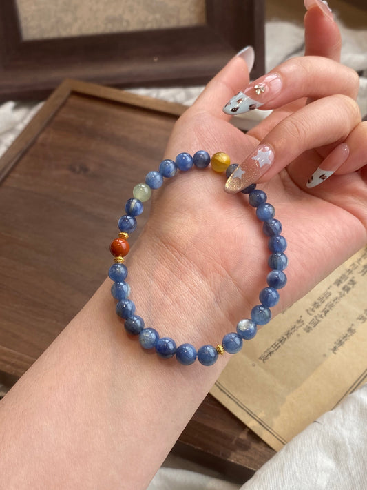 Hand wearing a kyanite bracelet with multicolored crystal accents – designed for energy cleansing, intuitive growth, and spiritual alignment.