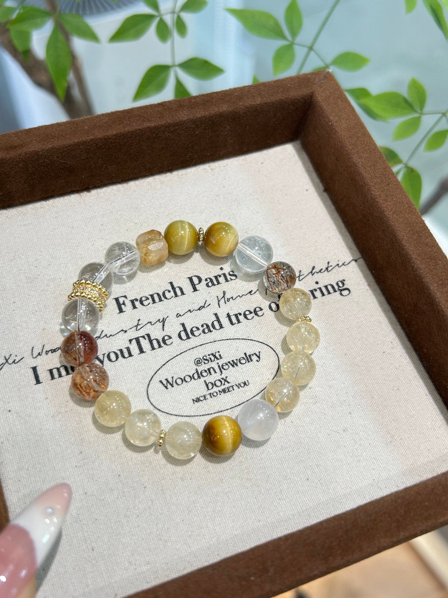 Hand holding a citrine-based multistone bracelet with moonstone, tiger’s eye, and rutilated quartz – a radiant symbol of wealth and empowerment.