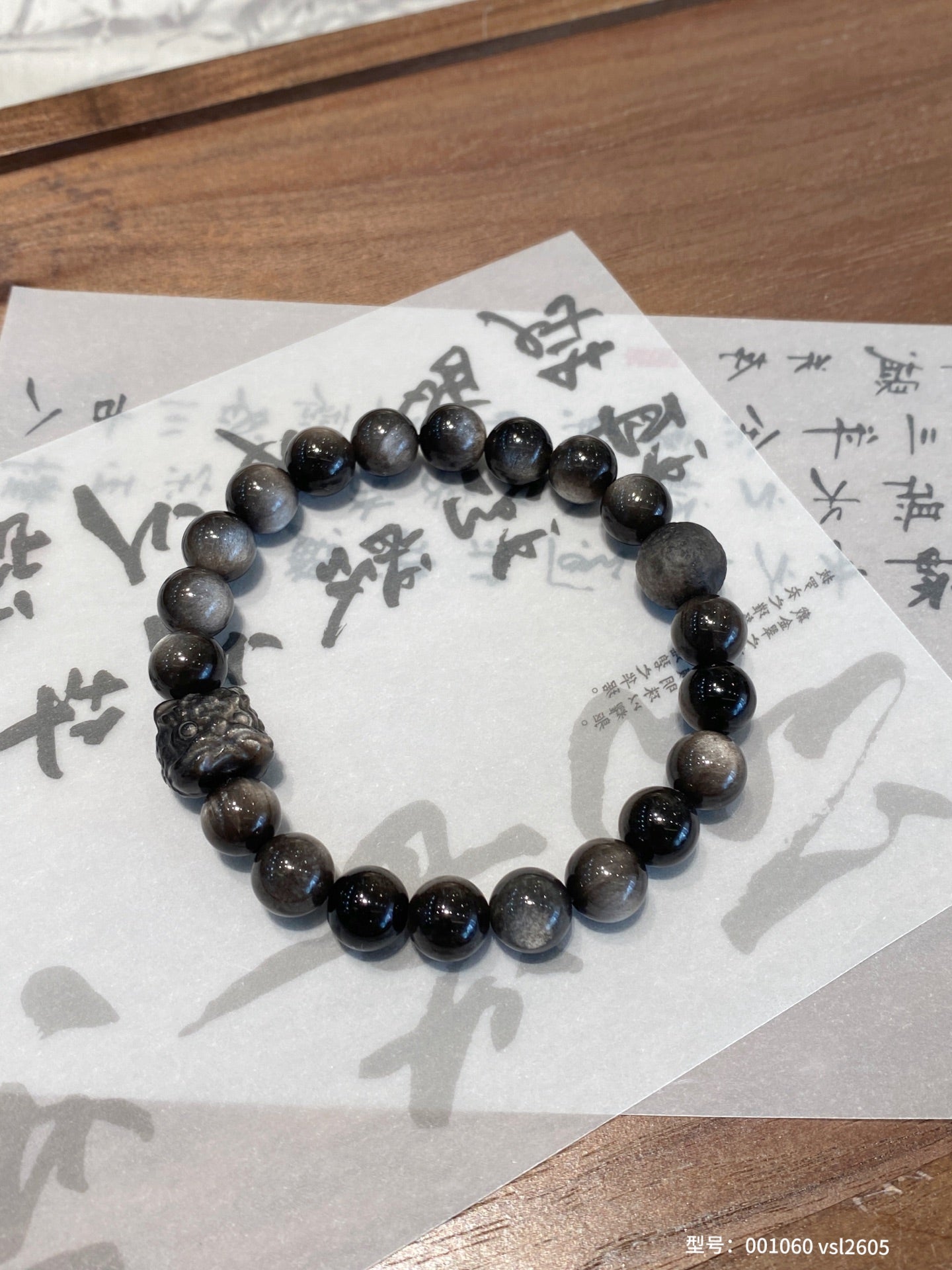 Silver sheen obsidian bracelet with carved Pi Xiu charm – designed for protection, wealth luck, and spiritual grounding.